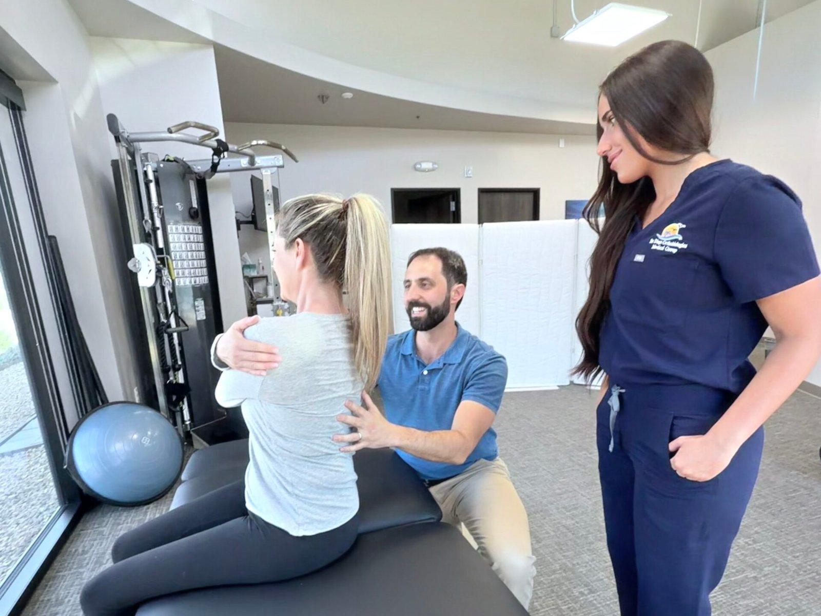 Dr. Ivan Vicario and Dr. Allie Anady working with a patient at Evolve DPT in Carlsbad, CA